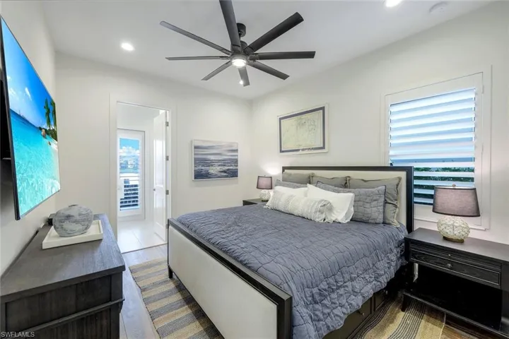 Bedroom featuring ceiling fan, multiple windows, and access to exterior