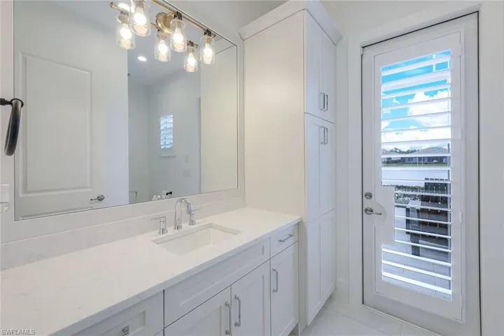 Bathroom featuring tile flooring, vanity, a water view, and an inviting chandelier