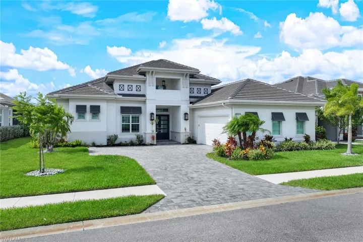 View of front facade featuring a garage and a front lawn