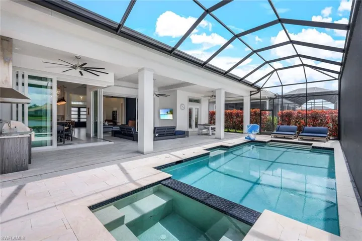 View of swimming pool with ceiling fan, an outdoor living space, an in ground hot tub, a patio, and a lanai