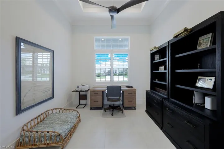 Tiled office featuring ceiling fan and a raised ceiling