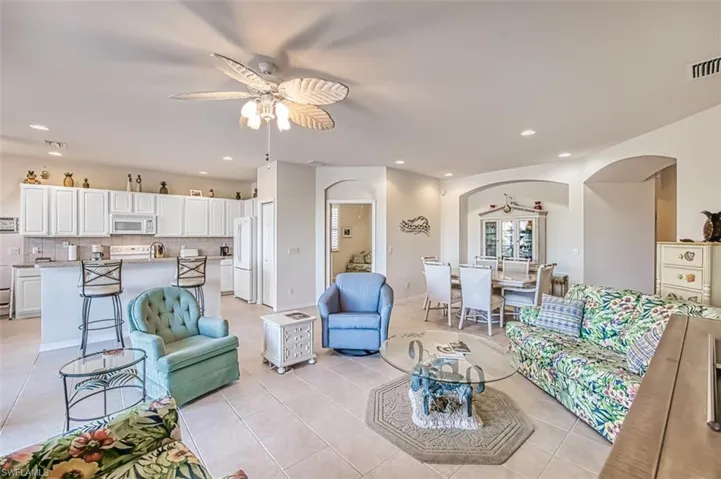 Living room featuring light tile patterned floors and ceiling fan