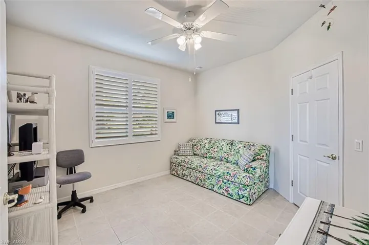 Office area featuring light tile patterned floors and ceiling fan