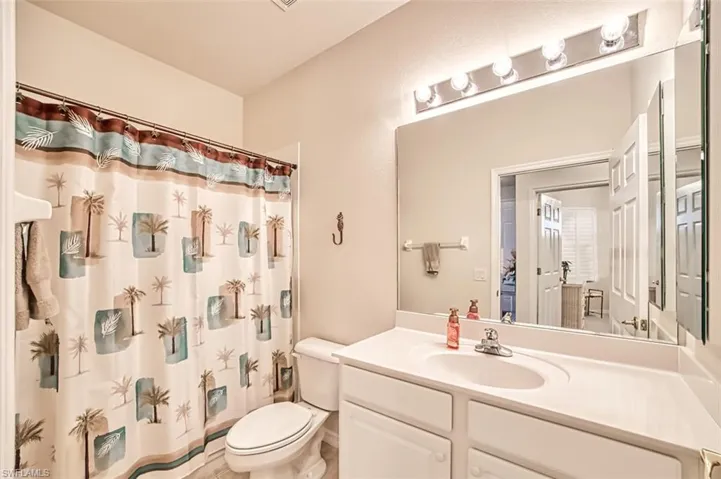 Bathroom featuring vanity, a shower with curtain, and toilet