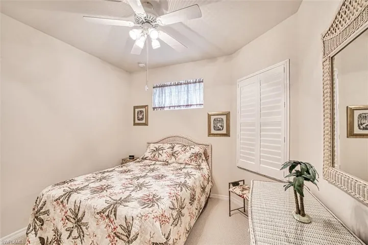 Carpeted bedroom featuring ceiling fan