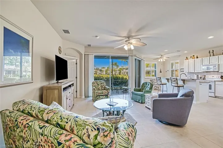Living room with light tile patterned floors and ceiling fan