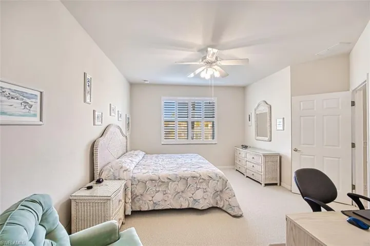 Carpeted bedroom featuring ceiling fan