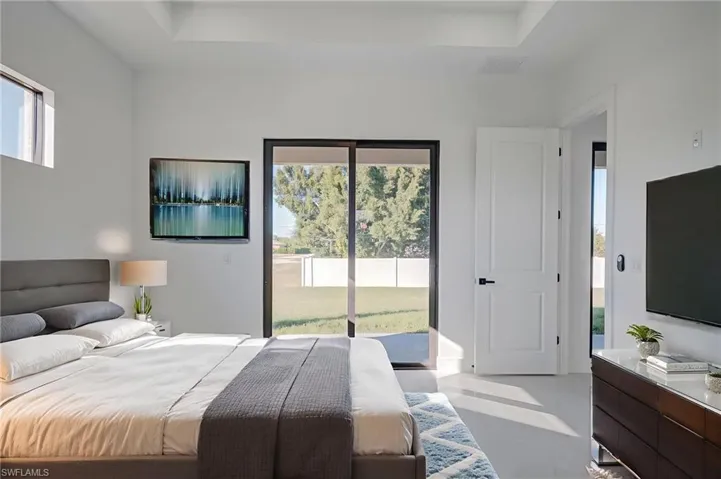 Bedroom featuring access to outside and a raised ceiling