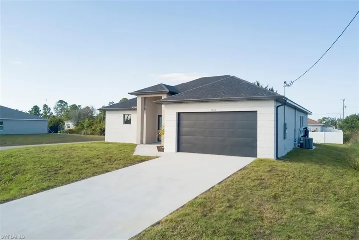 View of front of house with driveway, a garage, and a shingled roof