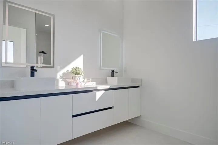 Bathroom featuring double vanity and baseboards