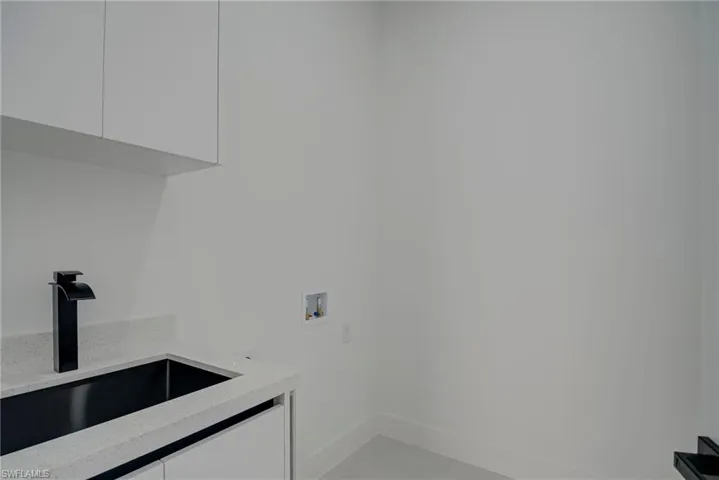 Laundry room with hookup for a washing machine and cabinet space