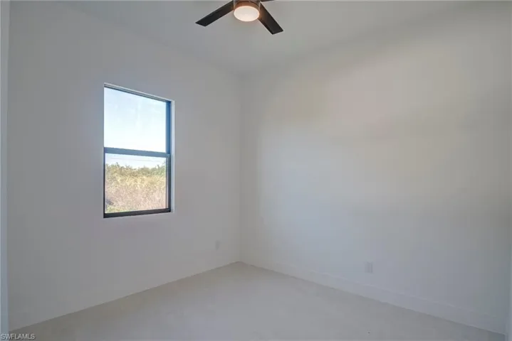 Empty room featuring baseboards and ceiling fan
