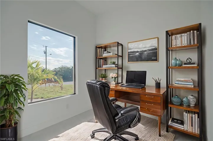 Office space with baseboards and concrete flooring