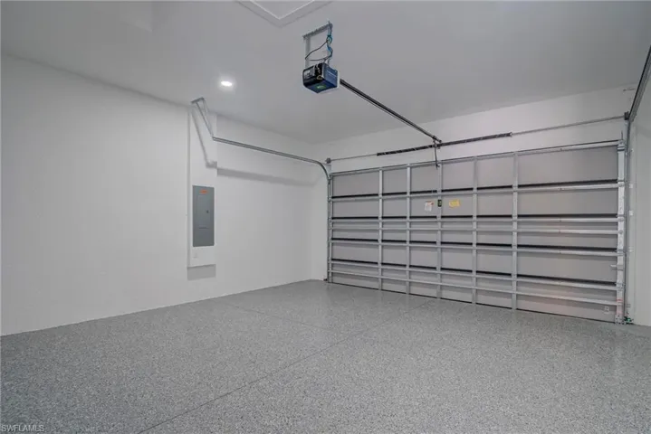Garage with electric panel and a garage door opener