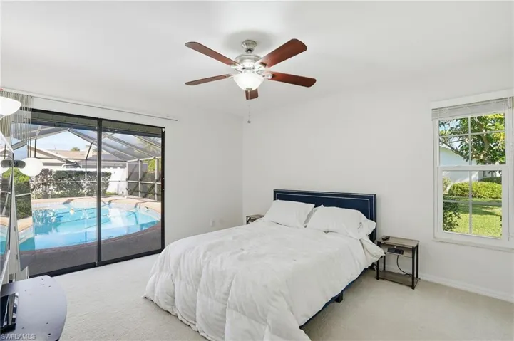 Bedroom with carpet, access to exterior, a ceiling fan, and a sunroom