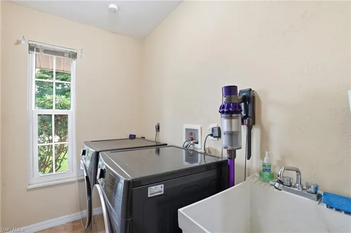 Washroom with baseboards and washing machine and clothes dryer