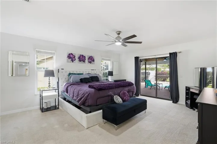 Bedroom with light colored carpet, access to outside, ceiling fan, and multiple windows