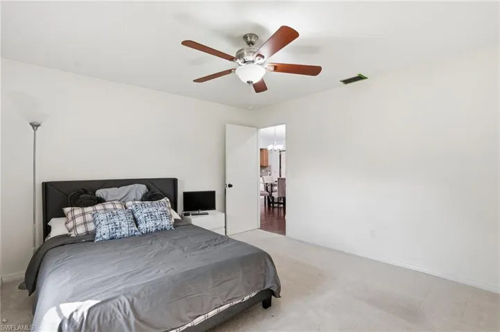 Bedroom featuring light colored carpet and a ceiling fan