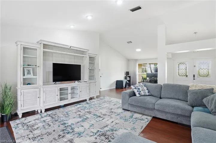 Living room featuring dark wood finished floors and high vaulted ceiling