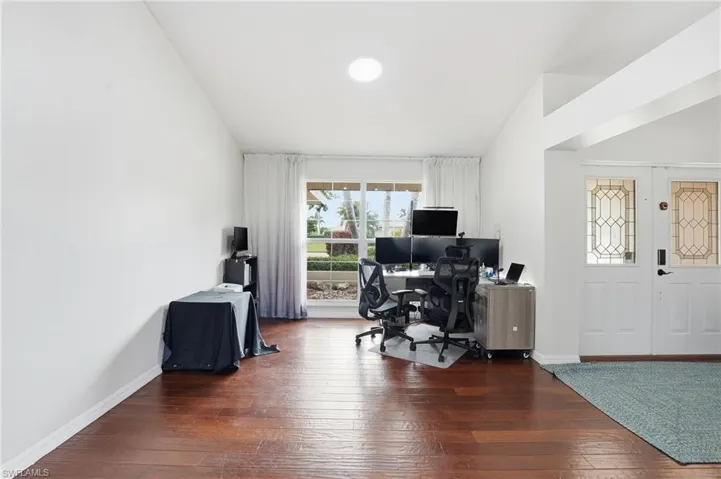 Office space with wood-type flooring and vaulted ceiling