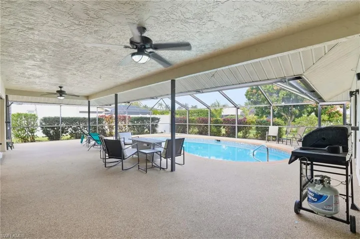 View of pool with a lanai, a sunroom, a patio area, and area for grilling