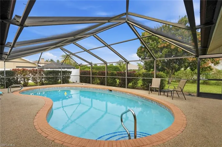 View of pool featuring glass enclosure, a sunroom, and a patio