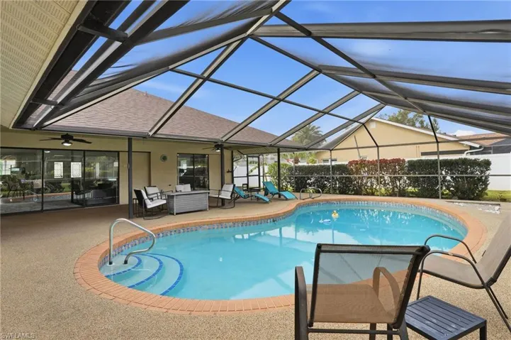 View of pool with a sunroom, a patio, glass enclosure, and an outdoor hangout area