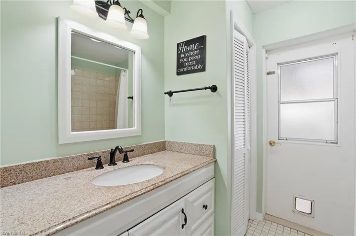 Bathroom featuring a closet, vanity, and a shower with curtain