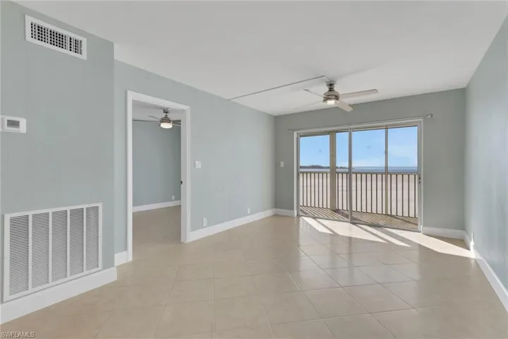 Empty room with ceiling fan and light tile patterned flooring
