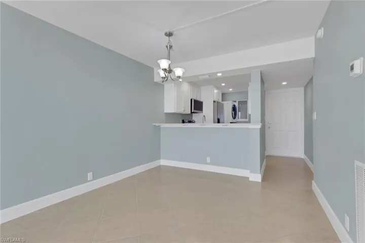 Empty room featuring a chandelier, recessed lighting, and light tile patterned floors