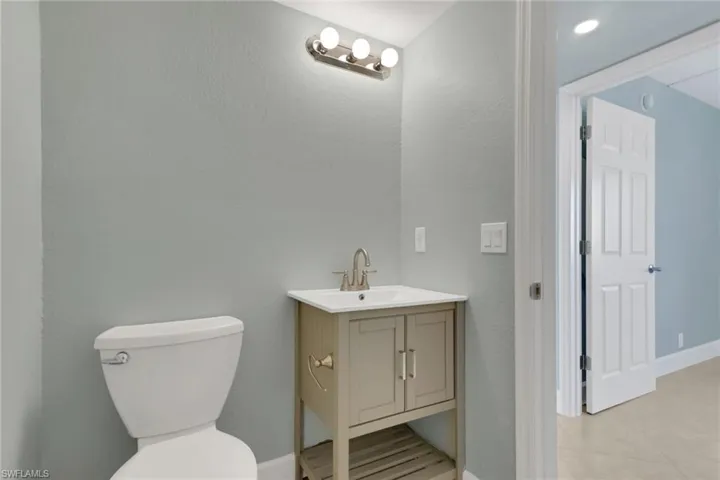 Half bathroom featuring a textured wall and vanity