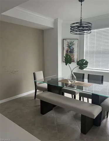 Dining area with ornamental molding and light tile patterned floors