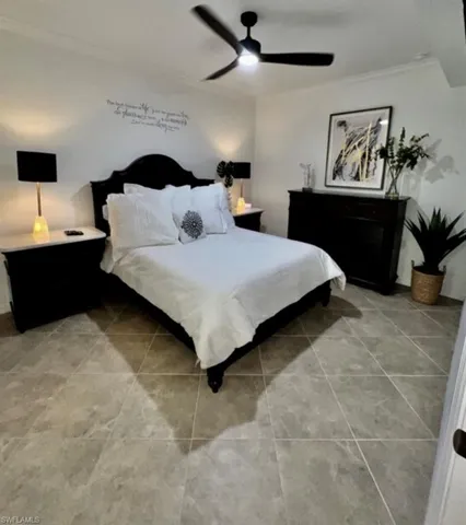 Bedroom featuring light tile patterned floors, crown molding, and a ceiling fan