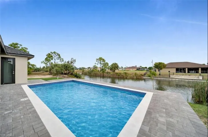 Swimming pool featuring a patio and a water view