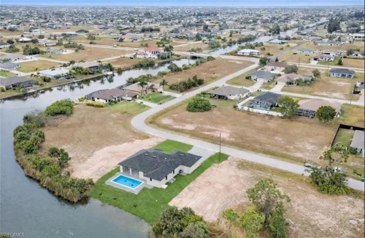 Aerial view of property's location with a nearby body of water and nearby suburban area