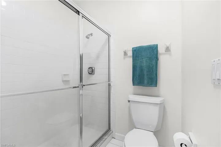 Full bathroom featuring two vanities, light tile floors, ensuite bathroom, separate shower and  bathtub