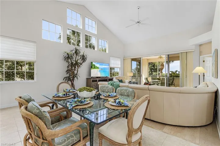 Dining area featuring a vaulted ceiling and wall of windows