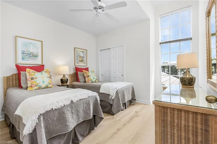 Bedroom #2 with light wood flooring, closet, large windows and ensuite bathroom