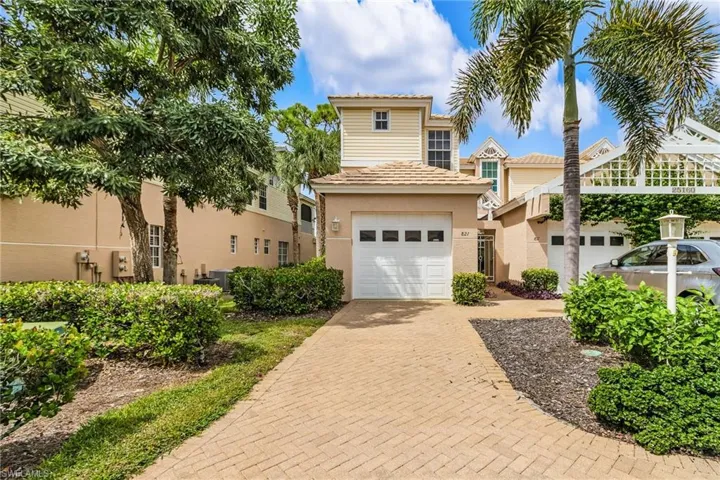 View of front facade featuring a garage, decorative driveway, stucco siding, and a tiled roof