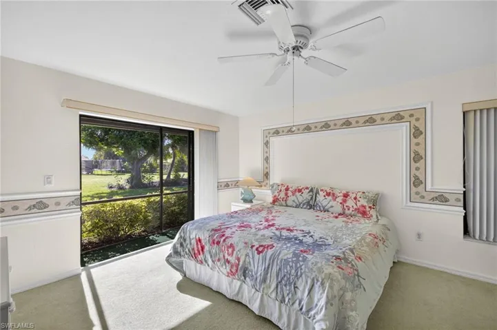 Carpeted bedroom with access to exterior and a ceiling fan