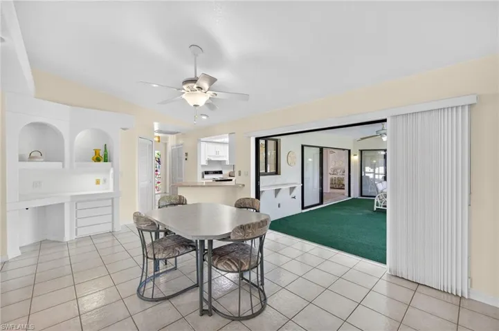 Dining area featuring ceiling fan, light tile patterned floors, plenty of natural light, and lofted ceiling