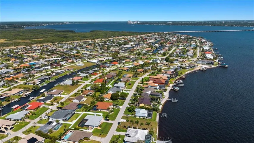 Aerial view of property and surrounding area with a large body of water and nearby suburban area