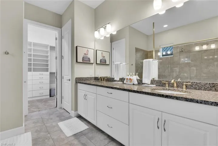 Bathroom with tile patterned flooring and dual bowl vanity