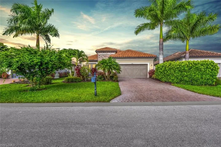 Mediterranean / spanish-style house with a garage and a lawn