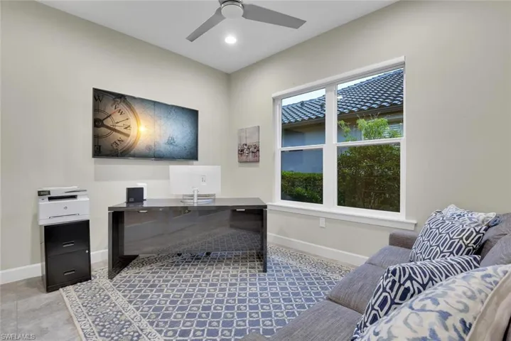 Office space with light tile patterned flooring and ceiling fan
