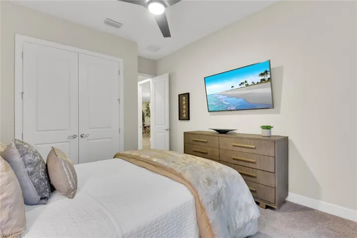 Carpeted bedroom featuring a closet and ceiling fan