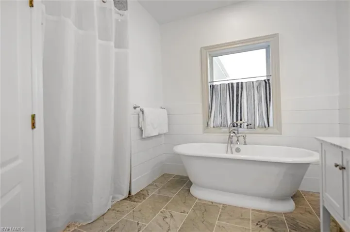 Bathroom with vanity and a bath