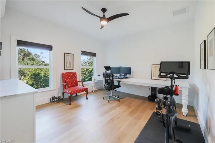 Office area with ceiling fan and light hardwood / wood-style floors