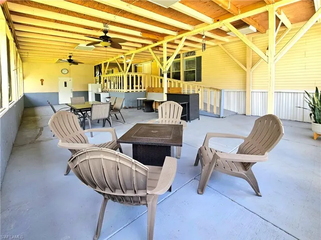 View of patio / terrace with a fire pit, outdoor dining area, and ceiling fan
