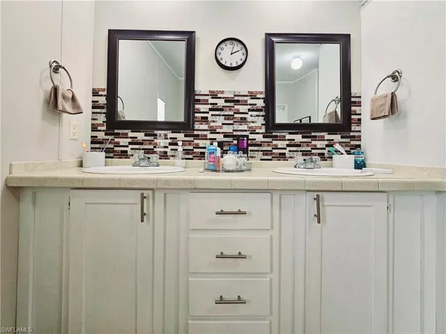 Full bath with double vanity and decorative backsplash